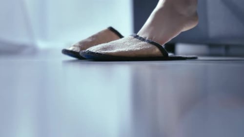 Bare Feet Step into Slippers by the Bed