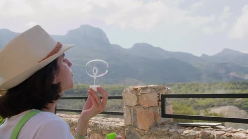 Brünette Frauen blasen Seifenblasen, sitzen in der Natur, Copy Space