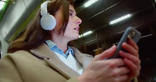 Low Angle Side View of Cute Beautiful Young Woman Travelling By Bus Listening to Music Chatting