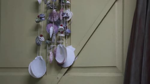 Beautiful And Colorful Sea Shells Hanging And Decorated On The Wooden Door, Gently Moving To Wind Fr