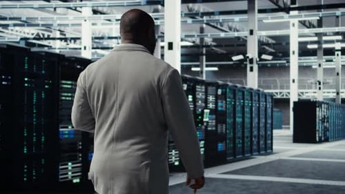 Engineer Walking in Server Farm Automating System Diagnostics