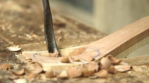 Woodworker Carving Wooden Object with Chisel