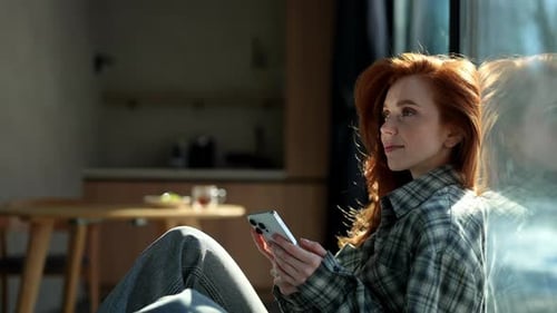 Woman Using Smartphone and Smiling Indoors