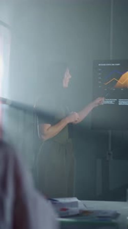 Business Analyst Presenting Digital Financial Charts on Large Screen in Modern Conference Room