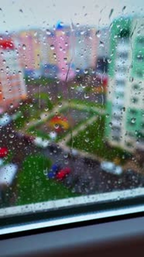 Rainy weather outside. View through the window with raindrops on glass