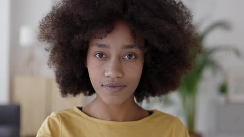 Young Woman with Afro Smiling Indoors at Camera