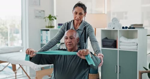 Senior Man Exercising with Therapist Using Resistance Band