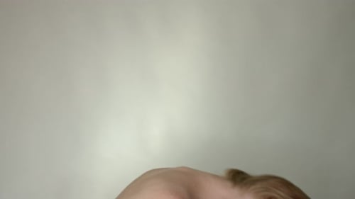 A close-up of a woman leaning over and flipping her hair back