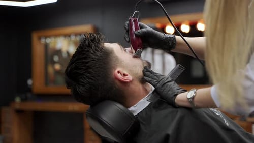 Barber Shaping Beard of Man in Barber Shop