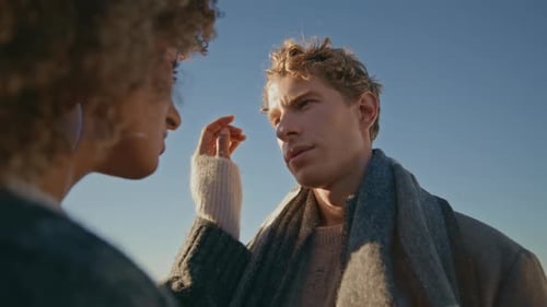 Affectionate Couple Embracing by the Ocean on Sunny Day