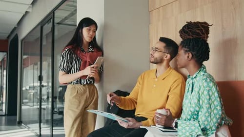 Young Professionals Discussing Work in Modern Office