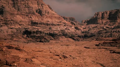Barren Desert Landscape Featuring Rugged Rock Formations Under Cloudy Sky