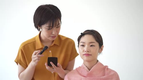 Woman Applying Makeup to Another Woman's Face