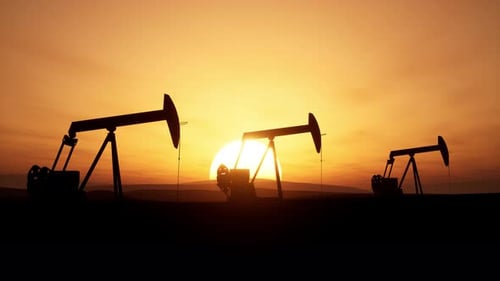 Pumpjacks Extract Oil Against A Sunset In A Peaceful Landscape