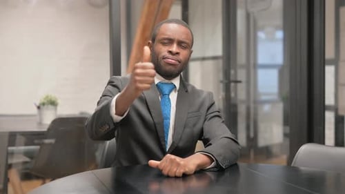 Smiling Business Man Gives a Thumbs Up in Office