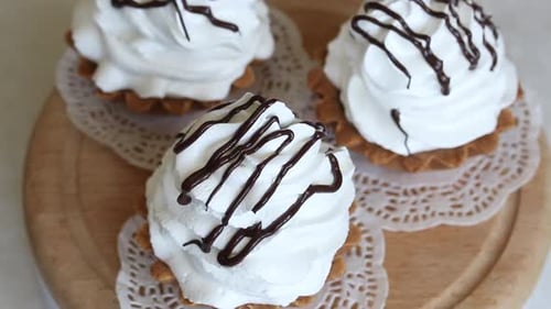 Kuchenkorb mit Schokoladen- und Buttercreme. Dreht sich in der Betrefftabelle. Von oben aufgenommen.