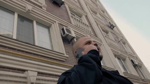 Street, sunny day - a man speaks on the phone