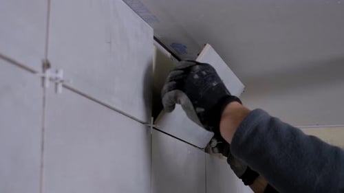 Worker Carefully Installs Tile in Home Renovation Project