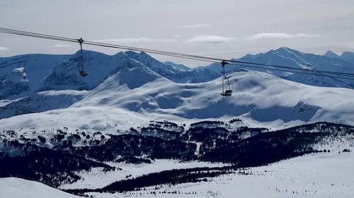 Chair lift at ski resort on snow covered mountain