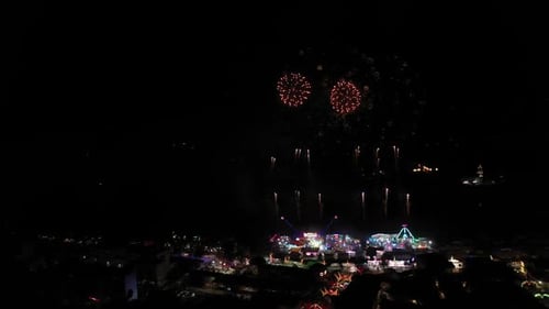 Vibrant Amusement Park with Colorful Fireworks at Night