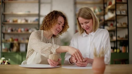 Un alegre equipo culinario trabaja en conjunto en el moldeo de masa con un enfoque en la técnica