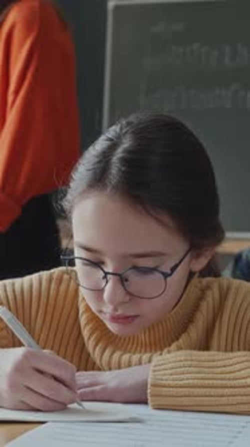 Little School Girl Writing Notes during Music Lesson