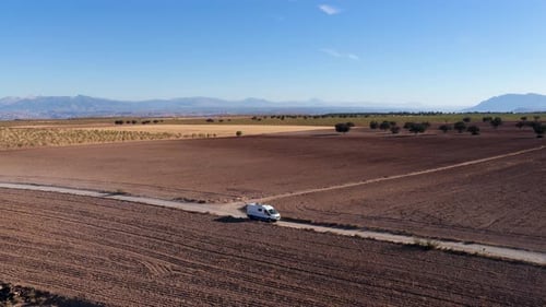 Camper Van Driving on a Dirt Road in the Gorafe Desert Spain