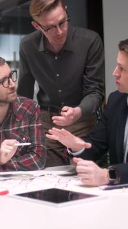 Men Collaborate on Project with Tablet in Workplace