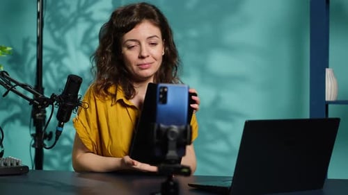 Woman Demonstrating Tablet and Smartphone in Home Studio
