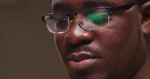 Close Up Face of Young Guy in Glasses Working and Typing on Laptop in Evening Handsome Afro American