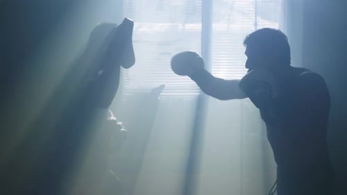 Two Men Boxing in Hazy Sunlight Room