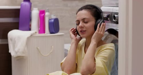 Woman Listens to Music in Laundry Room
