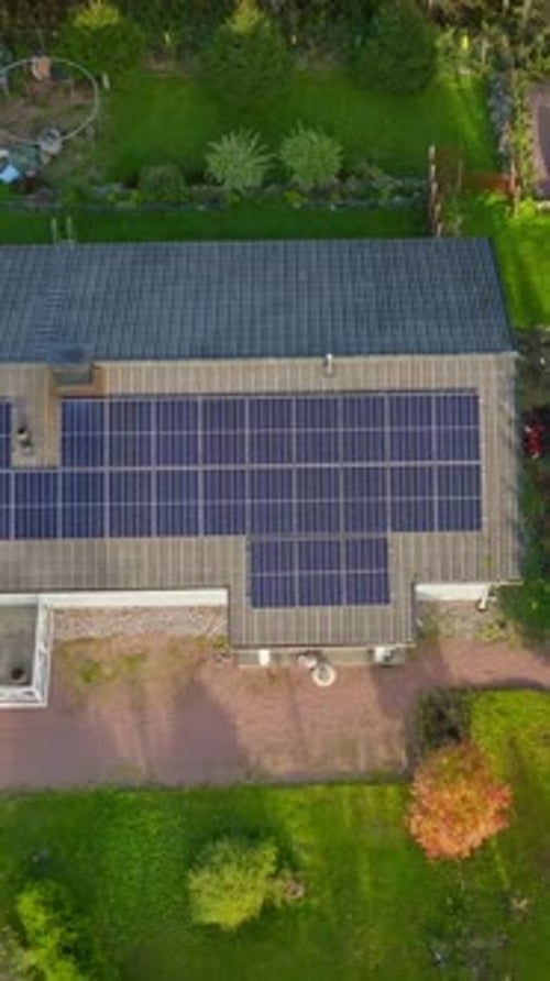 Vertical top down drone shot rising above a solar powered house, fall sunset