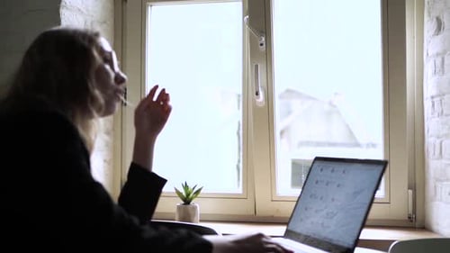 Young Woman Working on Her Laptop Computer in Coffee Shop