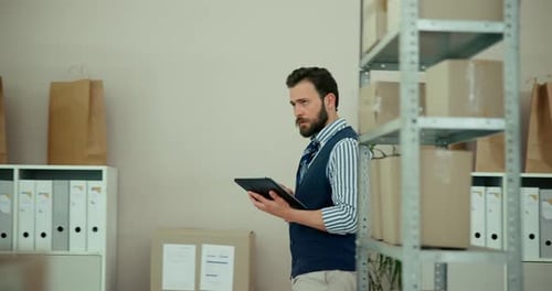 Man With Tablet Tracking Inventory In Warehouse