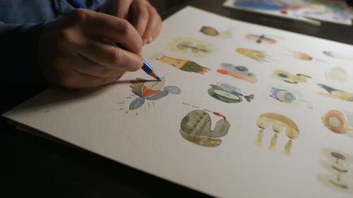 Hand holding color pencil and drawing colorful abstract shapes, close up