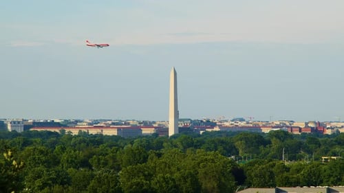 A commercial passenger jetliner airplane flies past the Washington, Monument in Washington, D.C. on