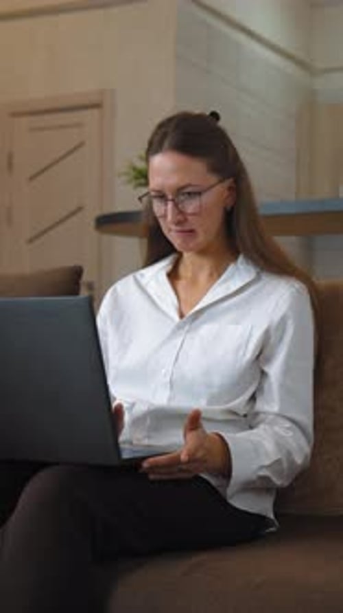 Woman Typing on Laptop While Sitting on Couch