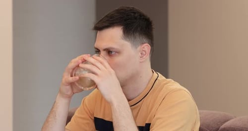 Caucasian Man Drinking Coffee in Kitchen at Home