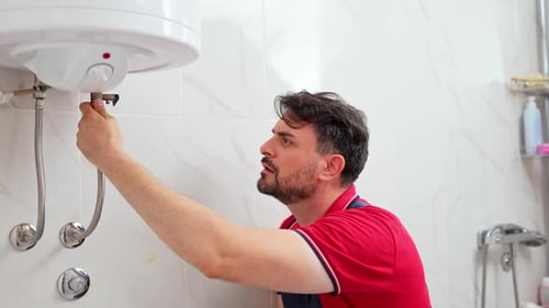 Plumber inspecting water heater installation in bathroom