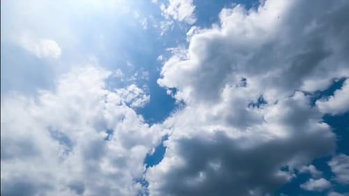 White and grey clouds transforming quickly in the blue sky. Sunny day cloudscape timelapse