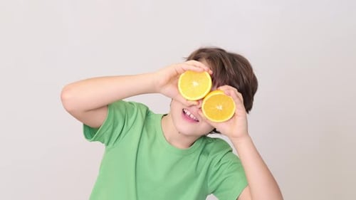 Smiling Boy with Orange Slices Over Eyes