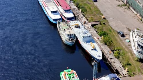 wide-angle shot of a sunny commercial port terminal. large white and red container ship is docked,