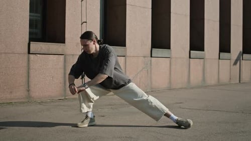 Man stretching legs in urban environment, working out