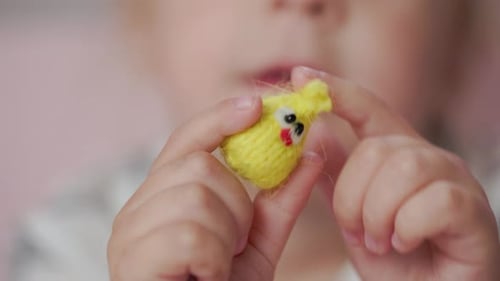 Mädchen spielt mit kleinen gestrickten Tierspielzeugen in einem Zimmer zu Hause
