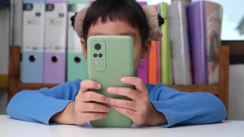 Young Child Plays on Mobile Phone Indoors
