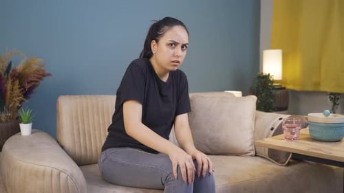 Young woman looking at camera with coward expression.
