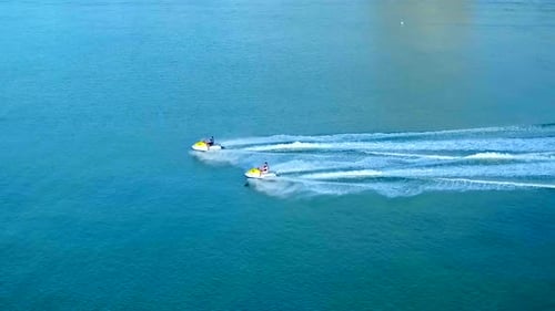 Two jet skis speeding across the blue waters of a tropical Florida paradise