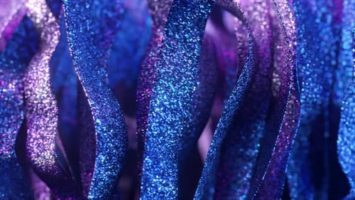 Shimmering Blue and Purple Ribbons Covered in Glitter Create a Mesmerizing Visual As They Flow and