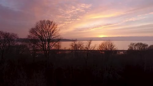 Lake Burtnieks in late autumn red sky sunset aerial wide view wit tree silhouette